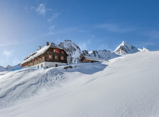 Wooden mountain hut in the alps in winter
