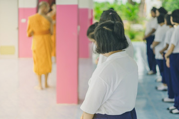 Group of students try to meditate for the peace of mind by walk with Buddhist monk in school.