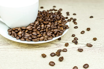 Coffee cup and coffee beans on wooden background