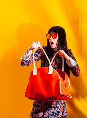 shopper woman yellow background red shadow bag brunette glasses funny shopping