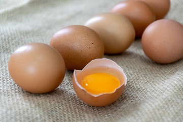 Fresh farm eggs with yolk in egg shell on sackcloth