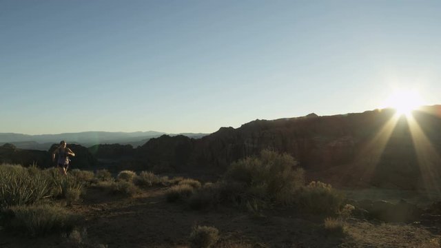 slow motion of girl trail running in desert