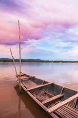 Dramatic clouds on the sunset sky over fishing boat on Mekong River.