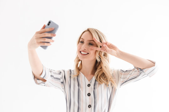 Photo of nice young woman taking selfie while smiling and showing peace sing