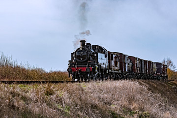 Fototapeta na wymiar Steam locomotive working hard pulling a train