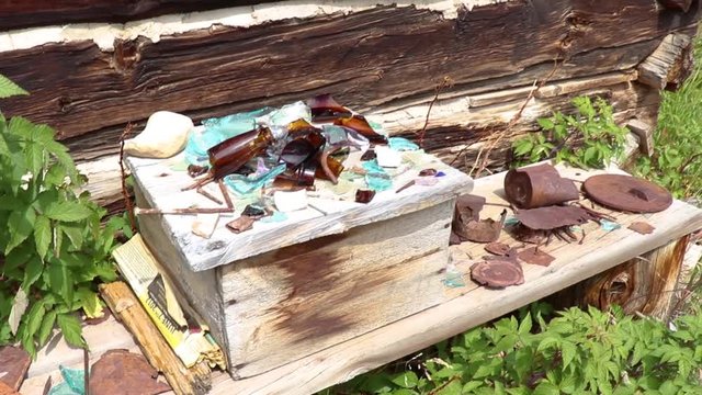 A pan of relics sitting in front of an old barn in a Colorado Ghost town.