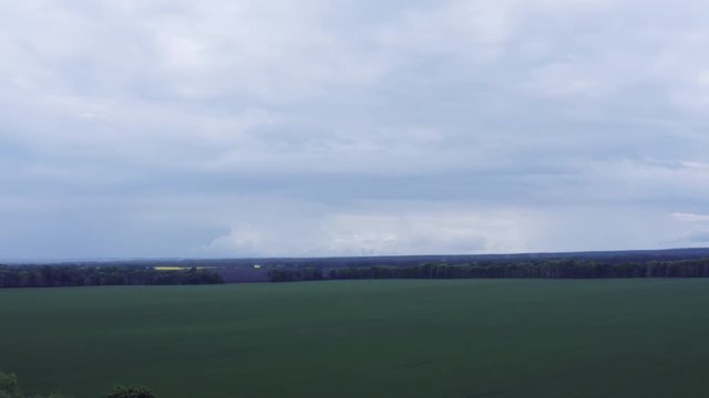 Aerial Flying over Blooming yellow rapeseed field with blue cloudless sky. Picturesque canola field under blue sky with white fluffy clouds. Wonderful 4k drone video footage for ecological concept