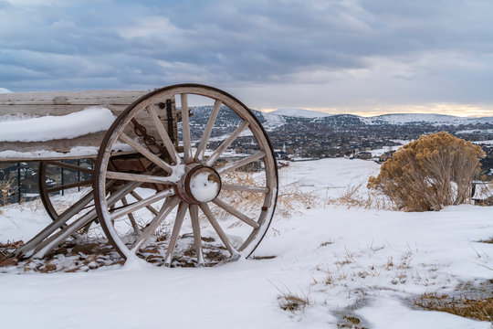 Old fashioned wooden wagon with rusty wheels on a frosted hill in winter