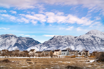 Facade of homes against a striking mountain dusted with snow in winter