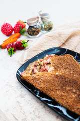 Black wheat and wheat galette topped with cooked ham and emmental cheese