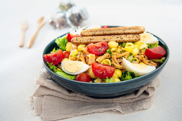 Salad made with cooked pasta, mixed green salads, cherry tomatoes, Mozzarella cheese and smoked ham served with accompaniment