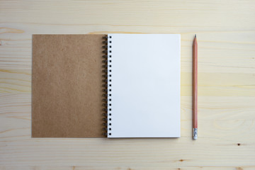 Top view open blank notebook and pencil on a light wooden table, copy space