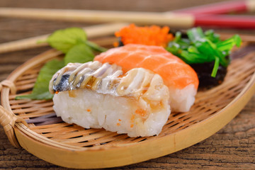 Sushi Set nigiri and sashimi served in bamboo plate on wooden background