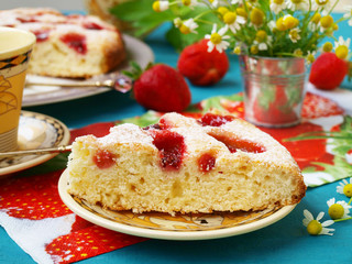 Homemade pie with strawberries, located on a plate on a blue background