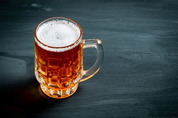 Mug with beer on black background.