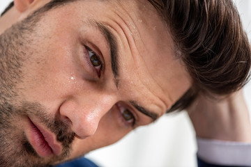 Fototapeta premium portrait of exhausted handsome man with sweaty face suffering from heat on white