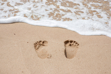 Footprints walking on the sand at the beach