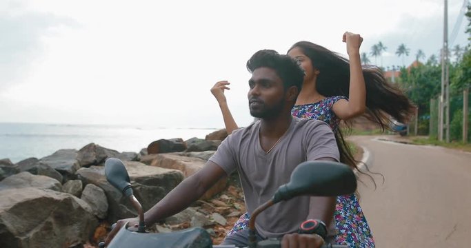 South Asian couple on a motorcycle rides along the Indian Ocean. in slow motion. Shot on Canon 1DX mark2 4K camera