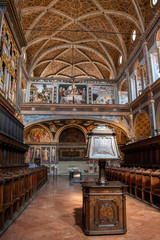 Fototapeta na wymiar Italy, 28/03/2019: the interior of San Maurizio al Monastero Maggiore, a 1518 church known as the Sistine Chapel of Milan, details of the Hall of nuns with the wooden benches where they sat to pray