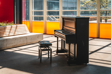 Piano and chair with bright sunlight from windows
