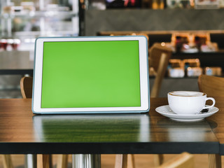 Green screen tablet and coffee mug on table, mock up. - Powered by Adobe