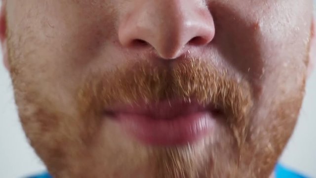 Caucasian young man watching a movie, eating popcorns and laughing, super close up