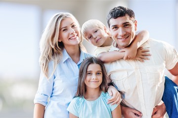 Beautiful smiling family sitting at sofa at home