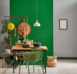 cooking utensils in front of the green wall, pot, wood fork and spoon, cutting board, chair lamp and frame style.