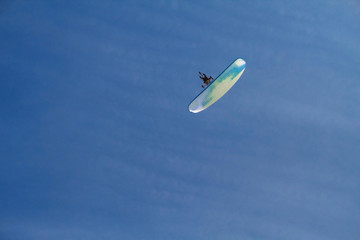 The paraglider flies over the clear blue winter sky. Free flight