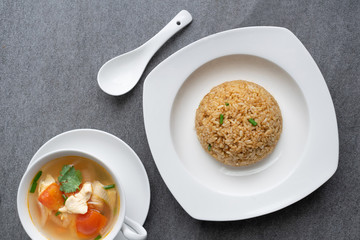 Garlic fried rice and hot soup chicken healthy at morning on concrete table.