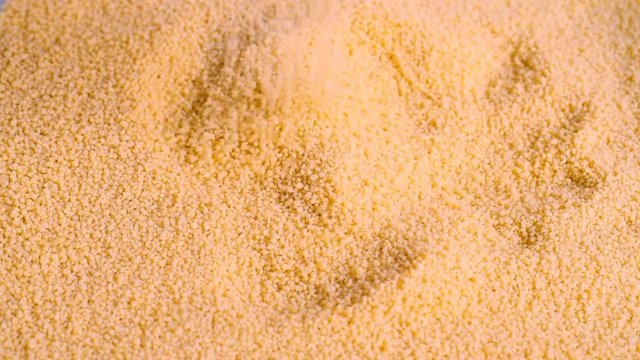 Chef hand picking a handful of durum wheat semolina, Arabic couscous, to prepare a traditional stew
