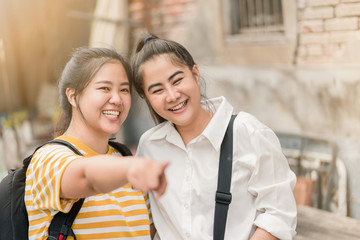 Asian woman and friend traveling to the old city in summer, She pointing something.