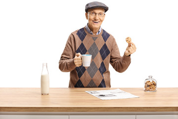 Senior posing with a cup and a biscuit