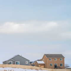 Square Facade of houses with a boundless cloudy sky background in winter