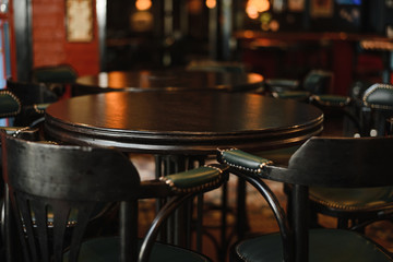  interior of Vintage european pub. barrel table with two vintage high chairs, dark interior and dark furniture.