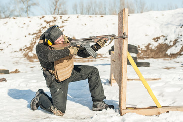 Special forces soldier in action, shooting from rifle machine gun