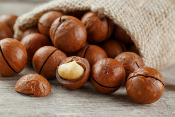 Macadamia nut on a wooden table in a bag, closeup, top view