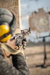 Special forces soldier in action, shooting from rifle machine gun