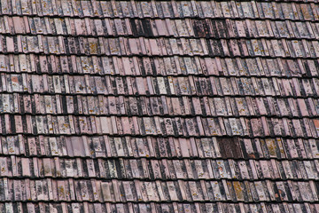 Old roof tiles on wooden traditional barn close up, image for background.