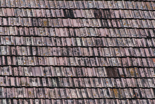 Old roof tiles on wooden traditional barn close up, image for background.