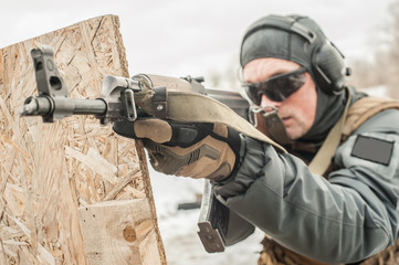 Special forces soldier in action, shooting from rifle machine gun