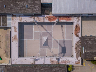 Aerial view of open square with pylon structure for tent in rusty industrial environment