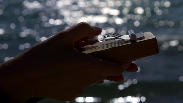 human playing on kalimba oldest musical instrument, close-up hands