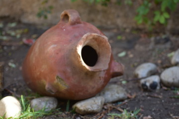 Vasija de ceramica color cafe sobre suelo lodoso