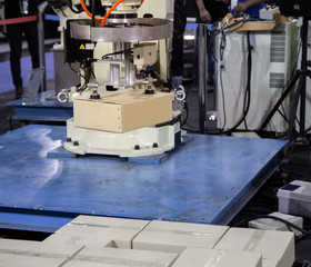 Industrial robot loading carton on conveyor in manufacturing production line
