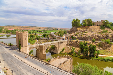 Fototapeta na wymiar Toledo, Spain. Alcantara bridge over the Tajo river and San Servando castle