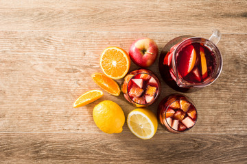 Red wine sangria in glass on wooden table. Top view