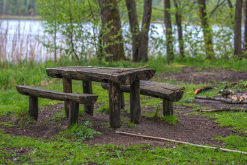 wooden table with bench by the lake in the forest