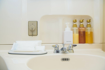 toiletry bag with travel toiletries, small plastic bottles of hygiene products and soap