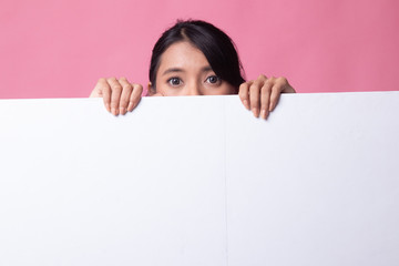 Close up of young Asian woman behind a blank sign.